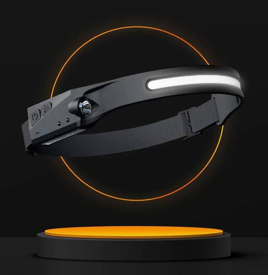 LED headlamp with a 230° wide angle beam, predominantly black in color, displayed on a stand with a glowing orange light below it.